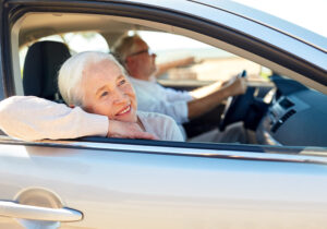 caregiving while traveling, senior woman leaning out car window